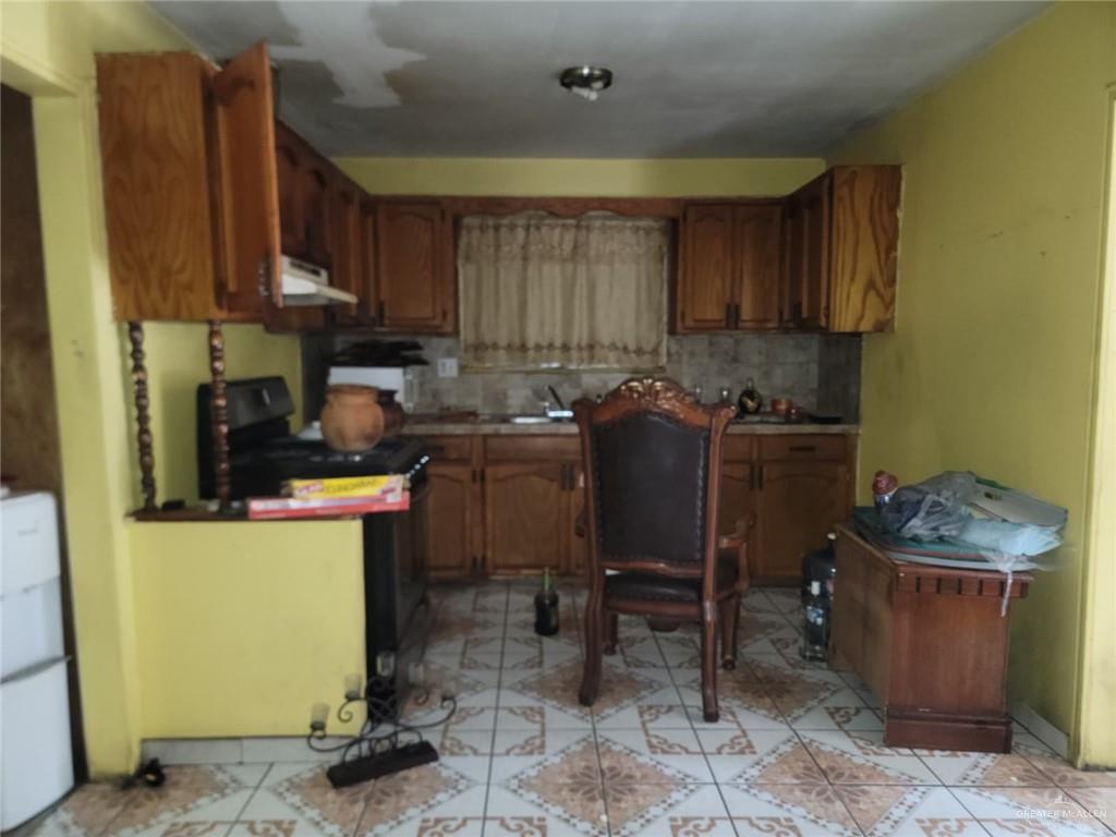 2132 Azteca Avenue McAllen, TX 78503 - Photo 13 of 17 a kitchen with a sink a stove cabinets and wooden floor