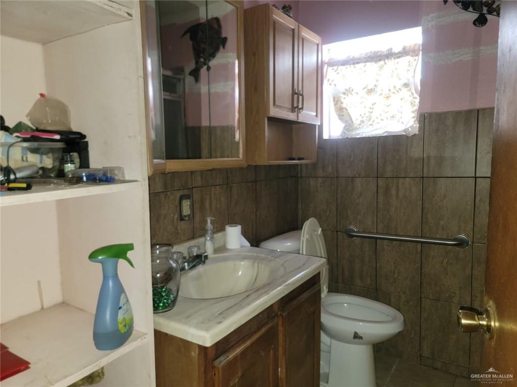 2132 Azteca Avenue McAllen, TX 78503 - Photo 14 of 17 a bathroom with a granite countertop sink a toilet and a mirror