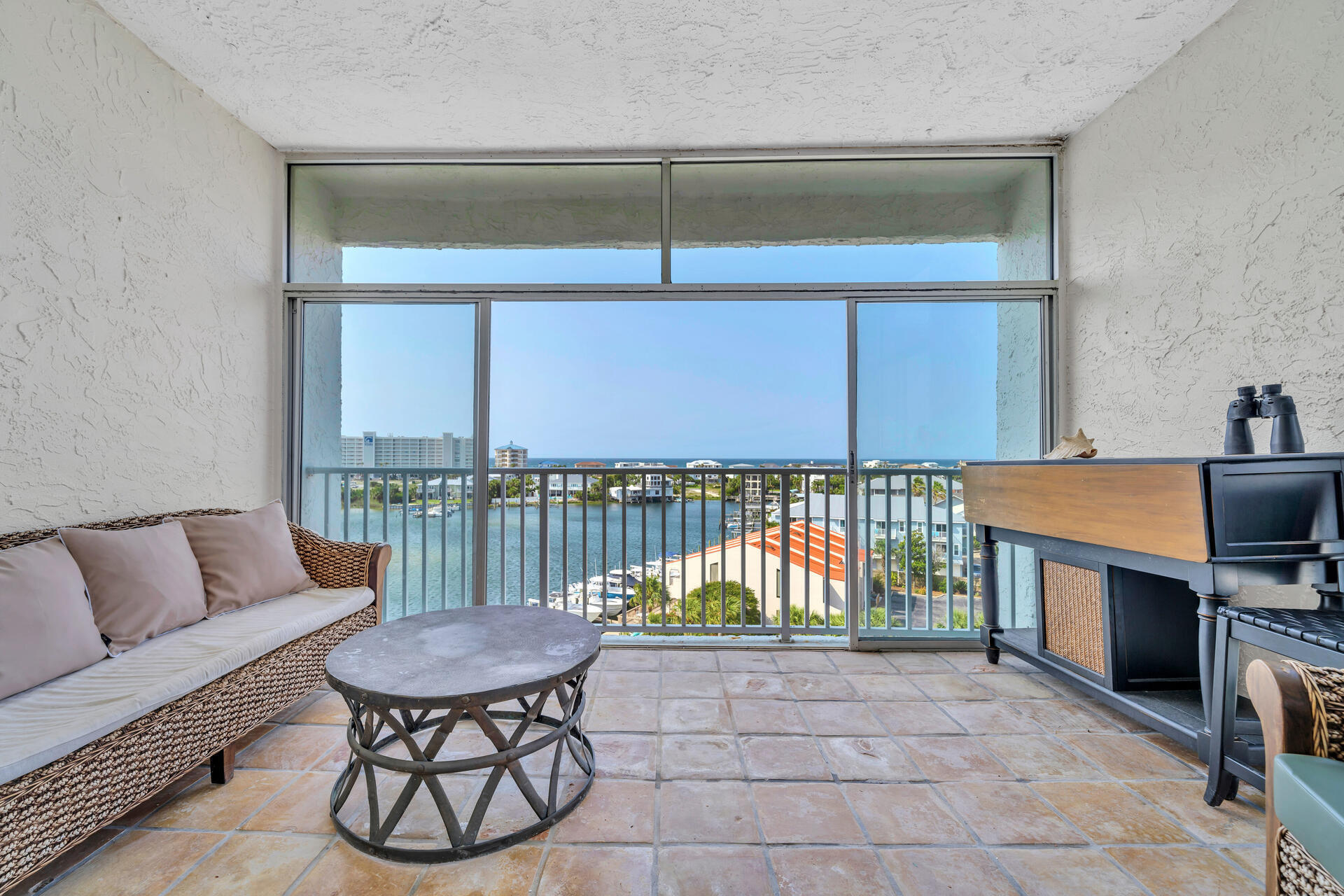 30 Moreno Point Road, Unit 704C Destin, FL 32541 - Photo 15 of 54 a living room with furniture a flat screen tv and a floor to ceiling window