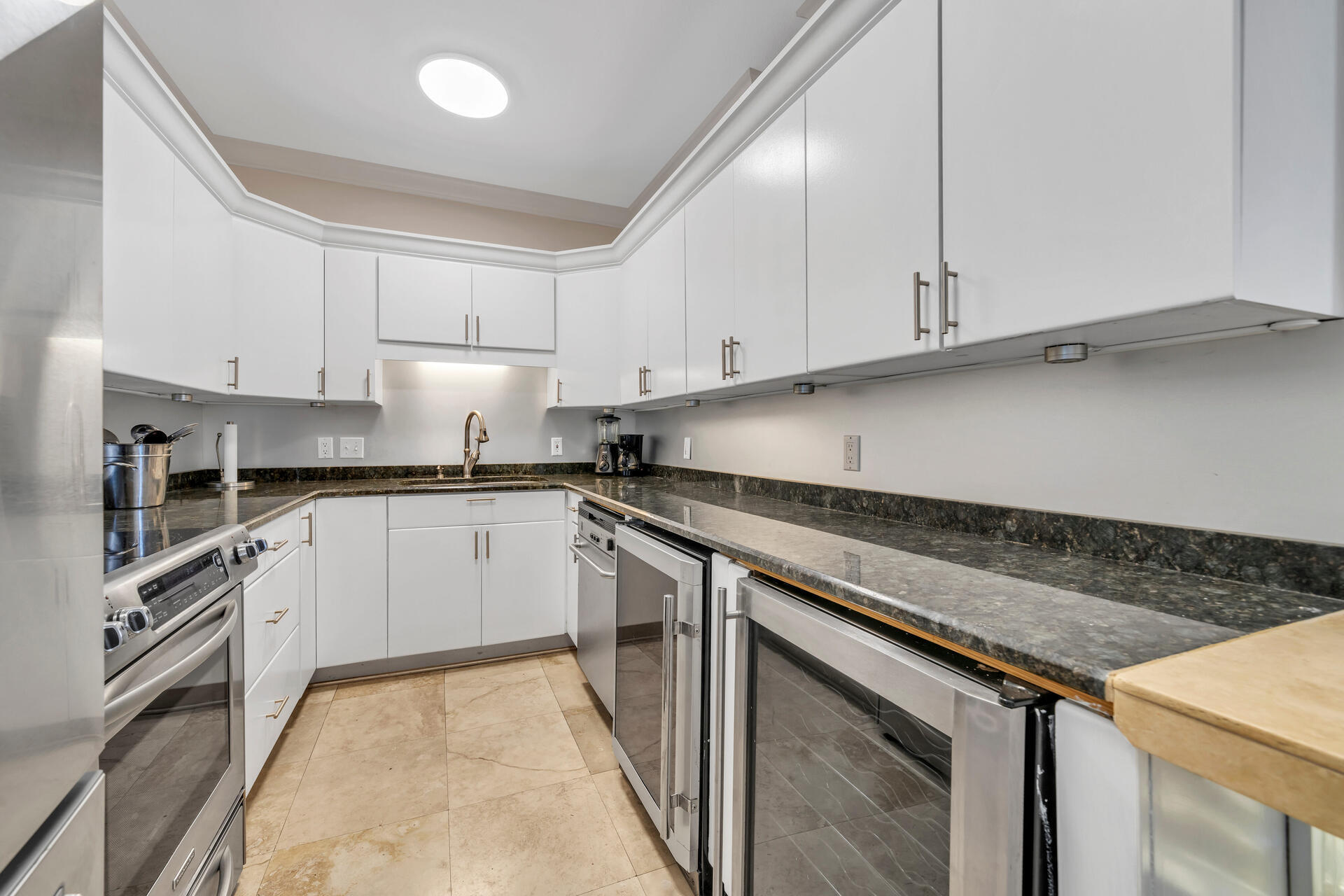 30 Moreno Point Road, Unit 704C Destin, FL 32541 - Photo 8 of 54 a kitchen with granite countertop white cabinets and stainless steel appliances