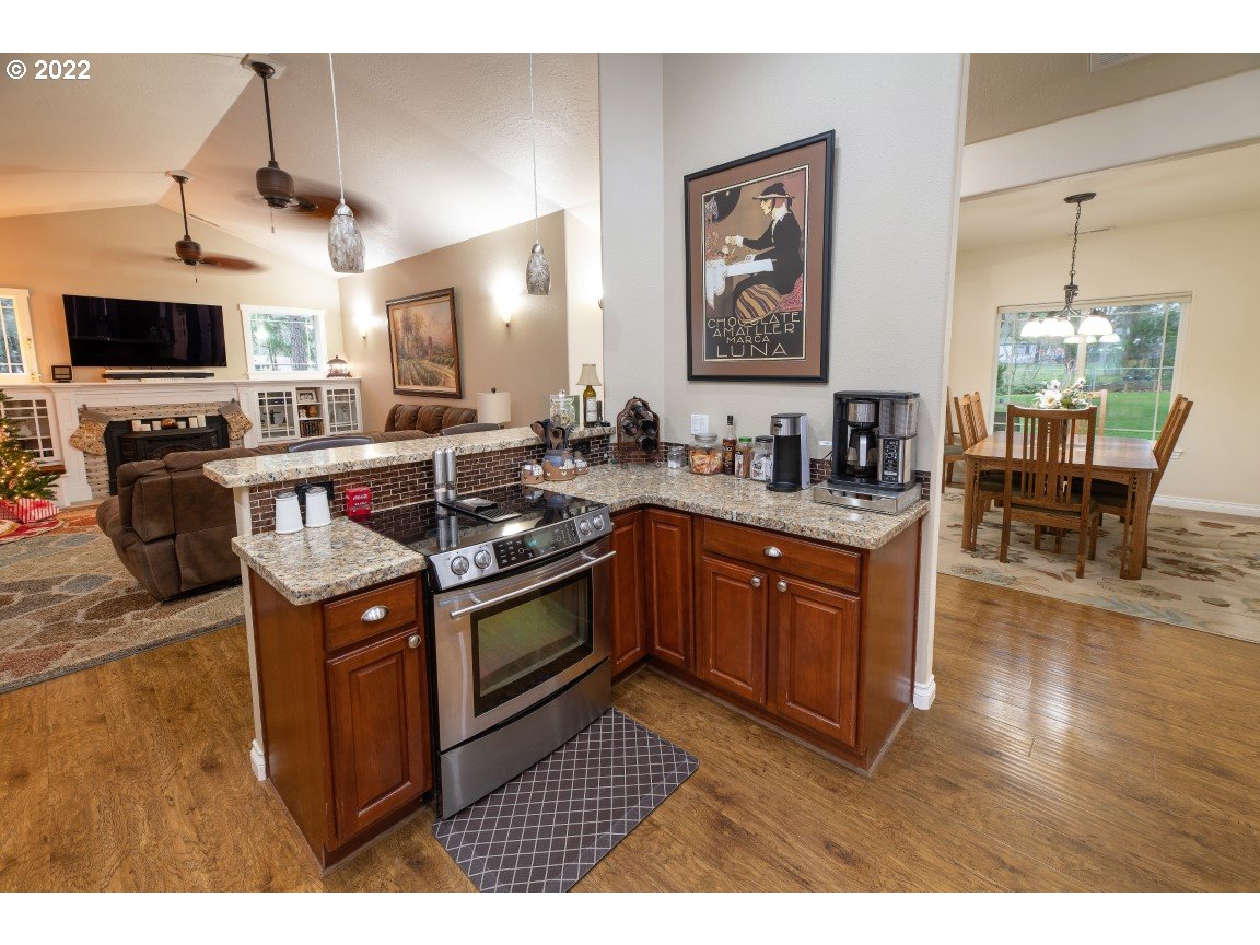 235 Boyer Road Grants Pass, OR 97526 - Photo 26 of 27 a kitchen with stainless steel appliances granite countertop a stove a sink dishwasher and a microwave oven with wooden floor