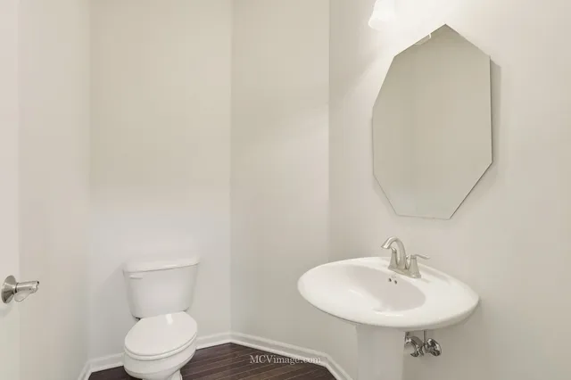 a bathroom with a sink a toilet and mirror