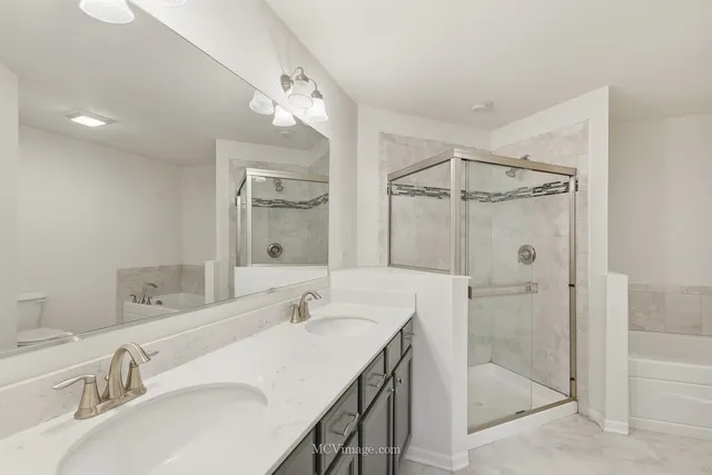 a bathroom with a double vanity sink mirror and shower
