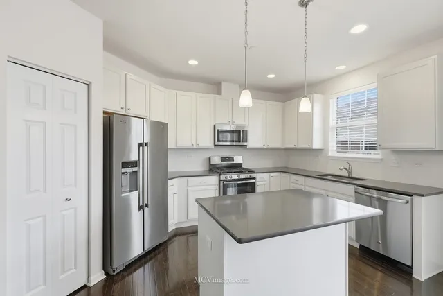 a kitchen with a refrigerator a sink and cabinets