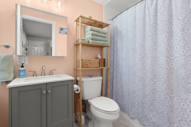 a bathroom with a granite countertop toilet sink and mirror