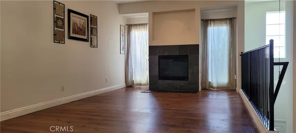 an empty room with wooden floor and a fireplace