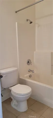 a white toilet and tub sitting next to a bathroom sink