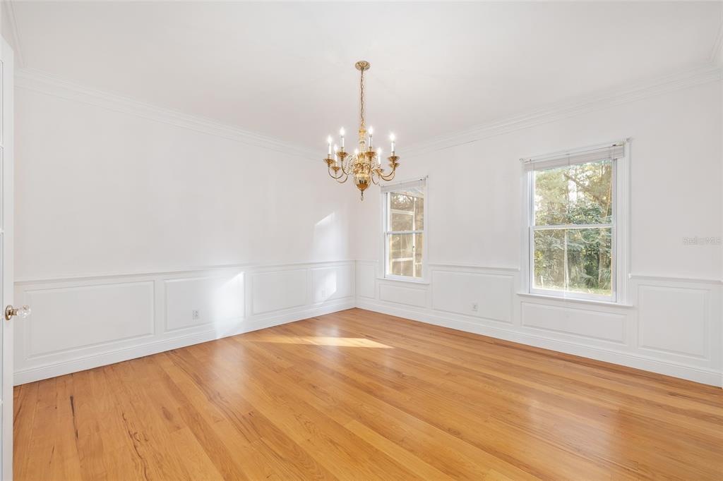 6581 South Magnolia Avenue Ocala, FL 34471 - Photo 23 of 59 an empty room with wooden floor chandelier and windows