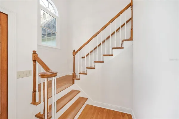 a view of a hallway with wooden floor and staircase