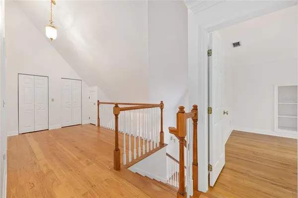 a view of an empty room with a window and wooden floor