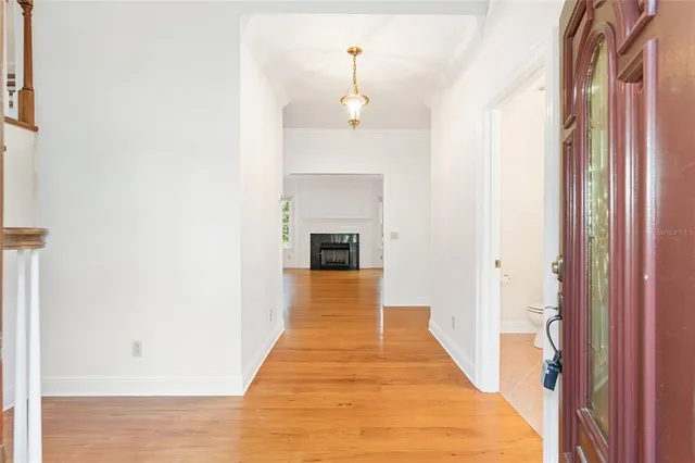 a view of a hallway with wooden floor and staircase