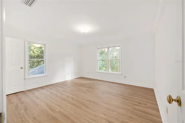 a view of empty room with wooden floor