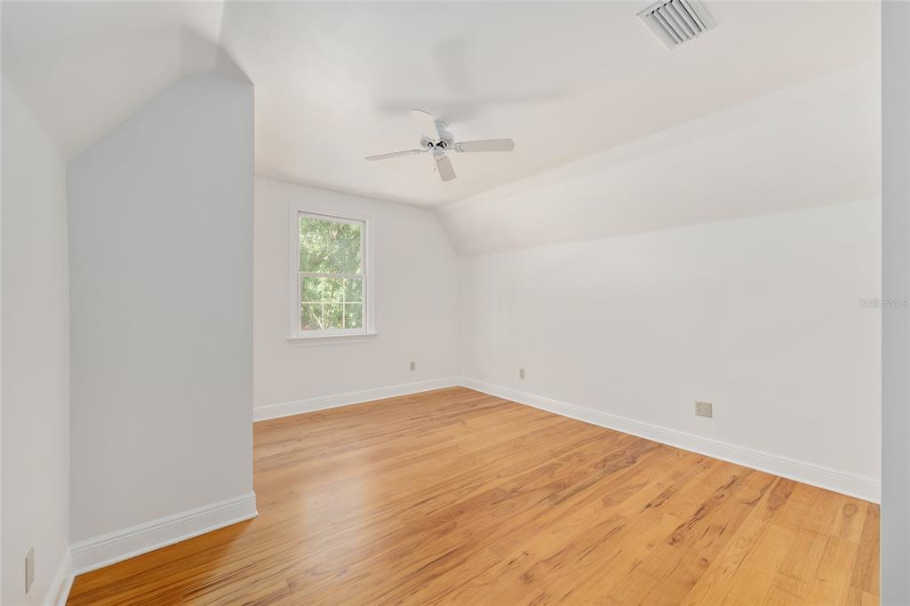 6581 South Magnolia Avenue Ocala, FL 34471 - Photo 43 of 59 an empty room with wooden floor ceiling fan and windows