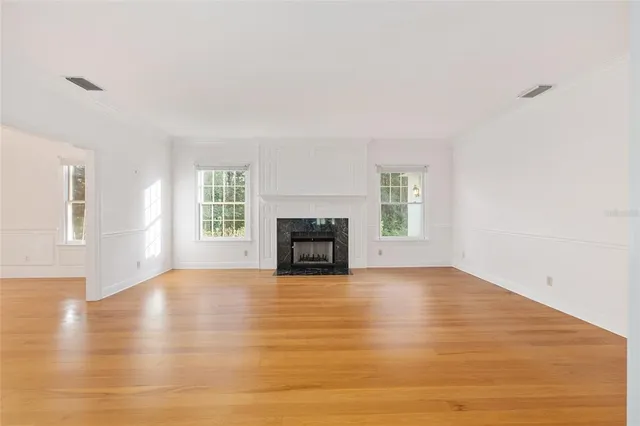 a view of empty room with wooden floor and fireplace