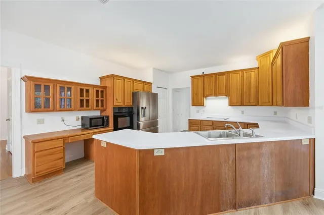 a view of a kitchen with a sink dishwasher and wooden floor