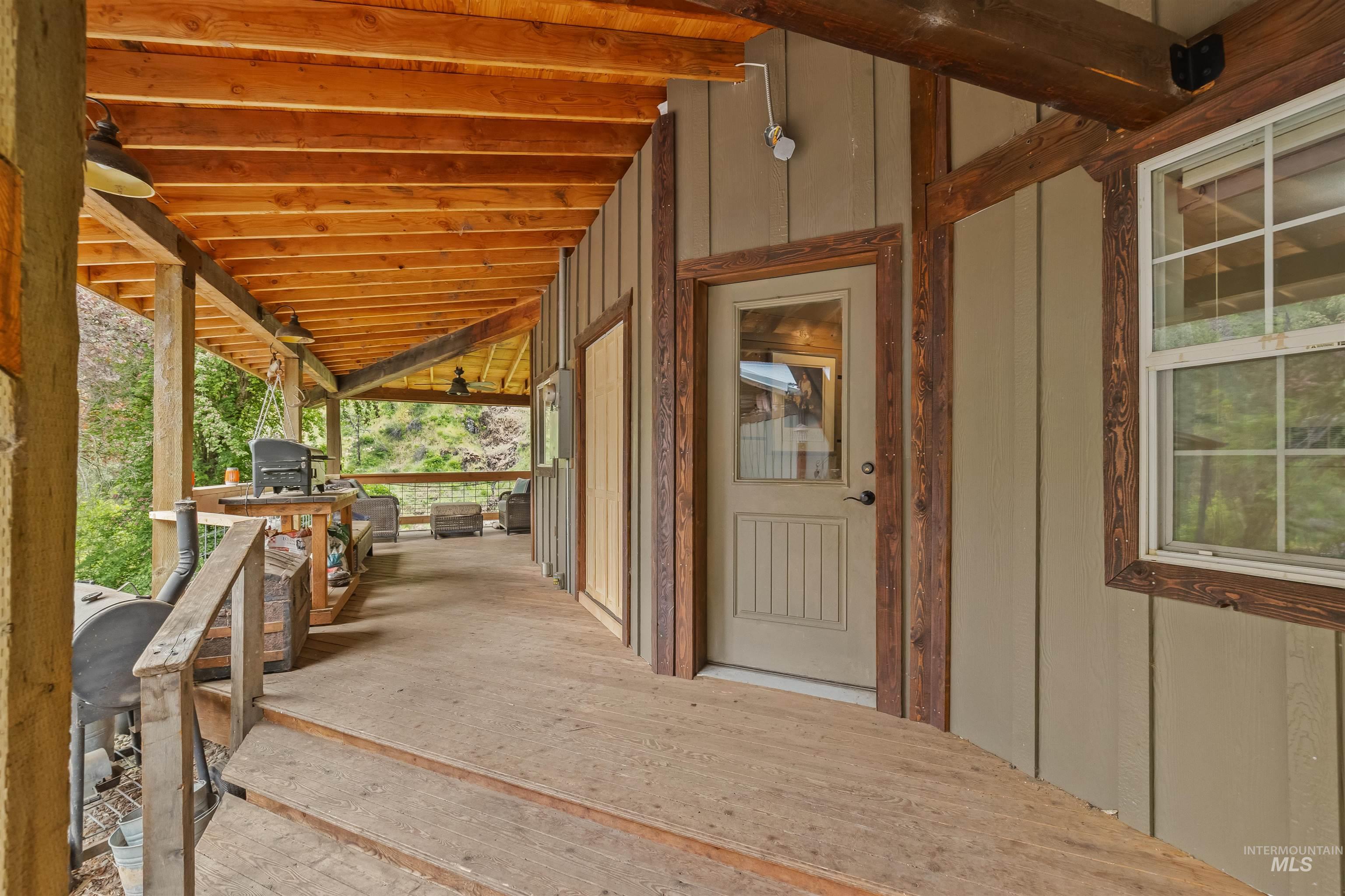 1314 Cedar Ridge Road Kendrick, ID 83537 - Photo 9 of 50 Expansive covered porch featuring wood-finish flooring, exposed wood beams, and a wood-framed window