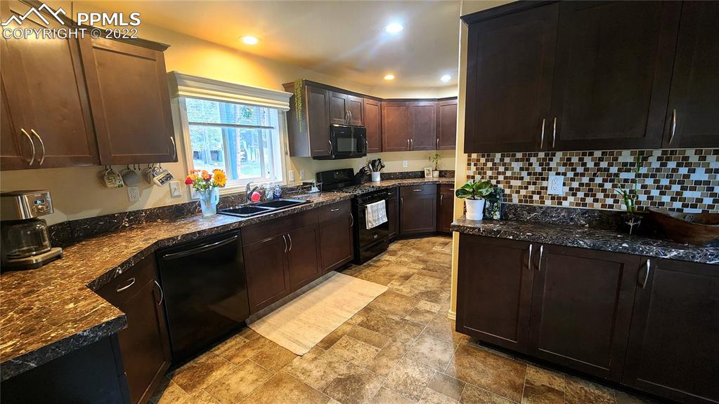 27650 Triple B Road Woodland Park, CO 80863 - Photo 2 of 18 a kitchen with kitchen island granite countertop a sink stove and refrigerator