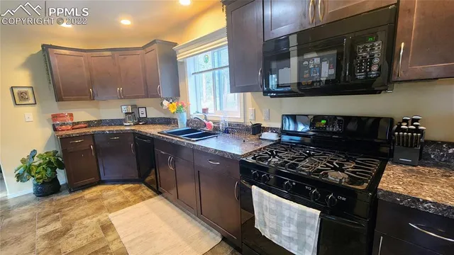 a kitchen with stainless steel appliances granite countertop a stove a sink and a microwave