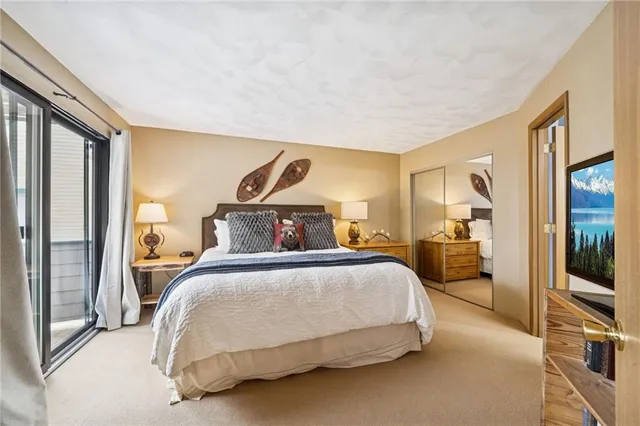 a bedroom with a bed a mirror and a window