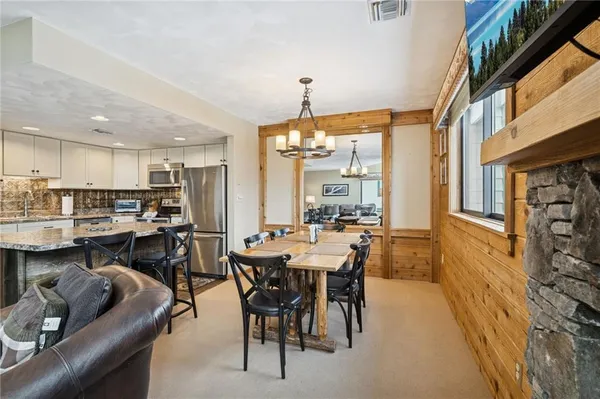 a view of a dining room with furniture and a chandelier