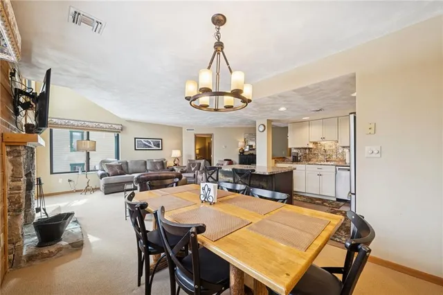 a living room with stainless steel appliances kitchen island granite countertop furniture and a refrigerator