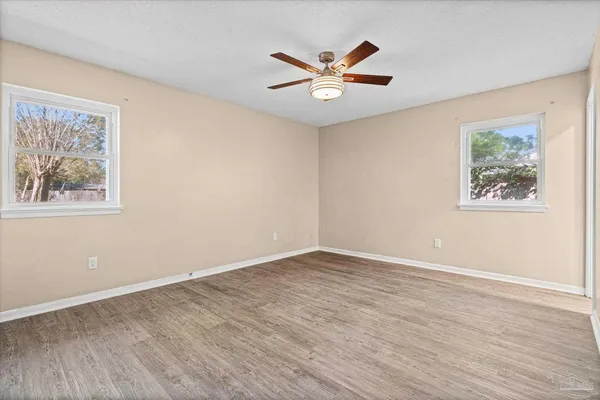 a view of empty room with wooden floor