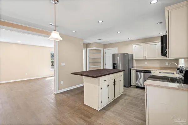 a kitchen with granite countertop a sink a counter top space stainless steel appliances and cabinets