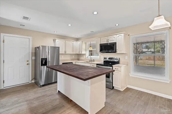 a kitchen with a stove a refrigerator and a sink
