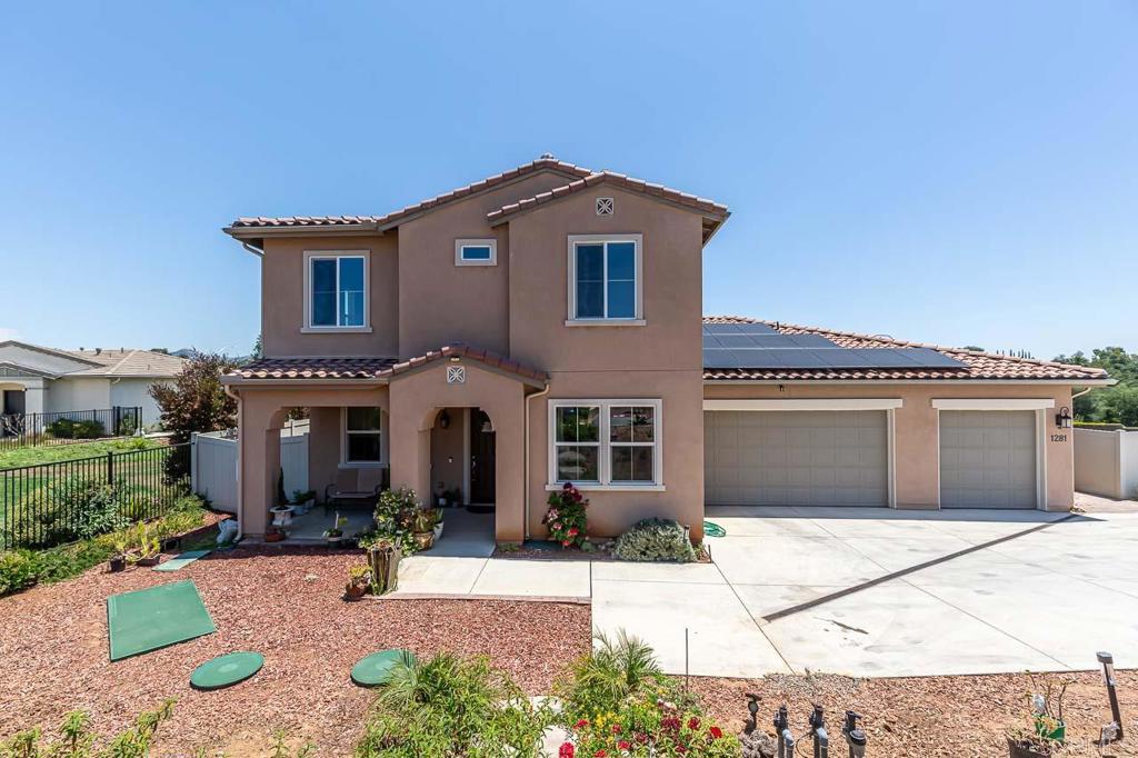 a front view of a house with a yard and potted plants