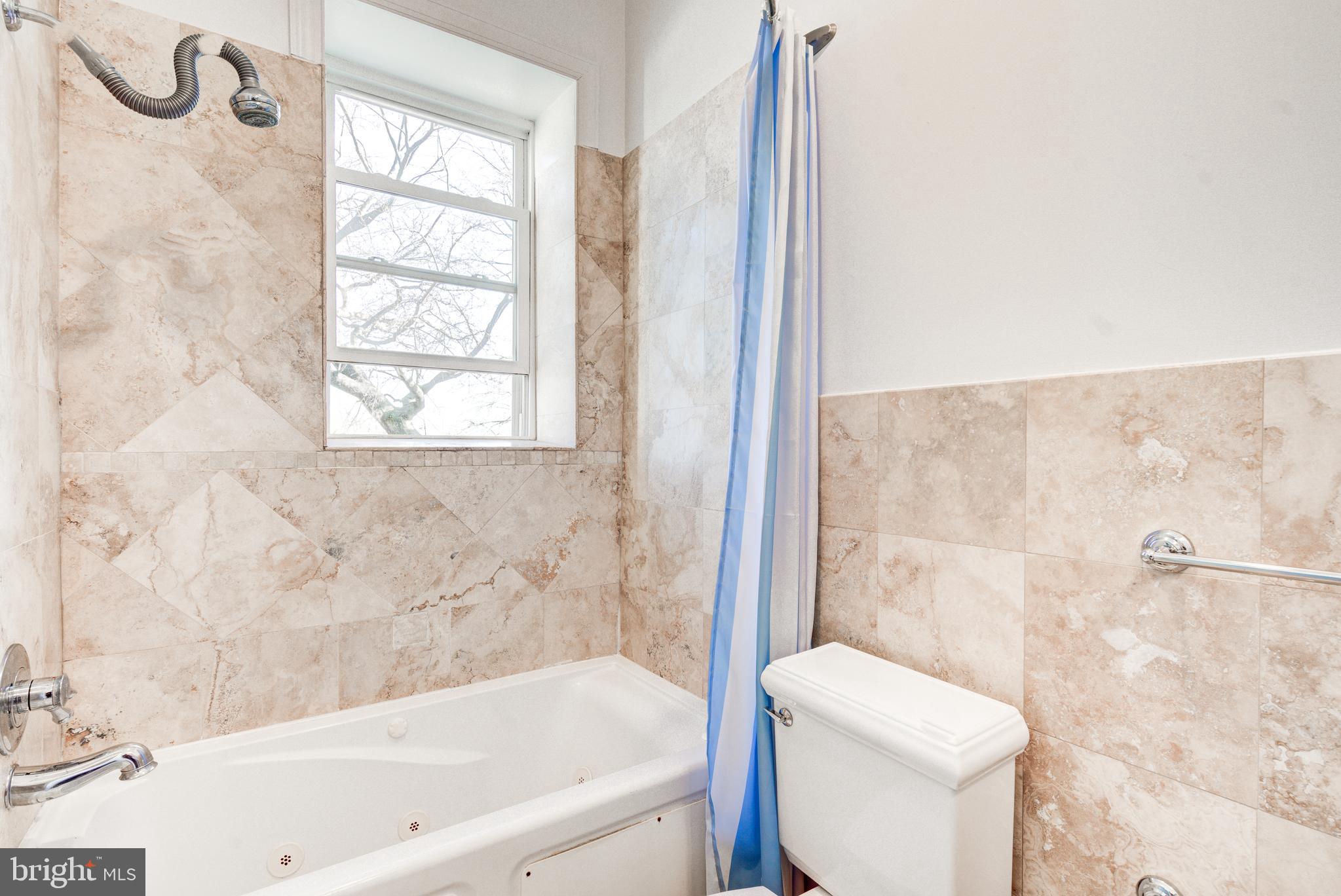 50 Rhode Island Avenue Northeast, Unit 2 Washington, DC 20002 - Photo 19 of 31 a bathroom with a granite countertop bathtub and a toilet