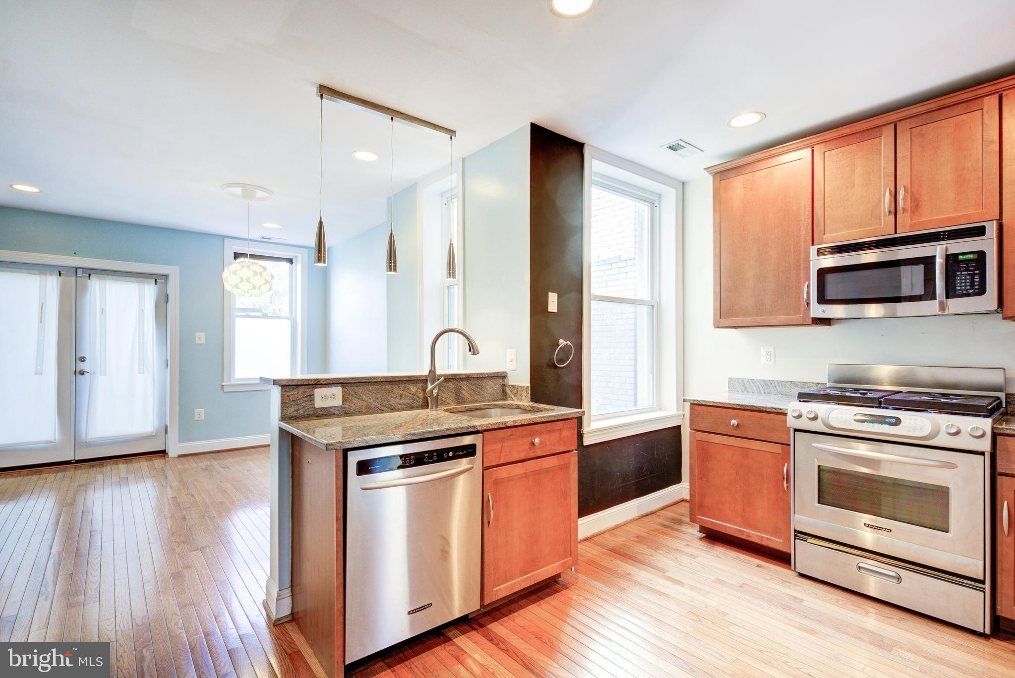 50 Rhode Island Avenue Northeast, Unit 2 Washington, DC 20002 - Photo 2 of 31 a kitchen with stainless steel appliances granite countertop wooden floors and granite counter tops