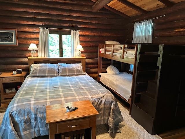 615 Kellys Lot Road Ely, MN 55731 - Photo 14 of 39 Bedroom featuring lofted ceiling with beams, log walls, and wooden ceiling