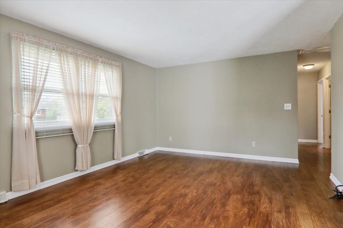 720 Lara Road Normal, IL 61761 - Photo 13 of 30 a view of an empty room with wooden floor and a window