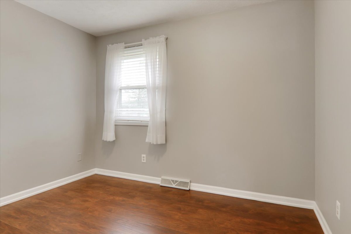 720 Lara Road Normal, IL 61761 - Photo 22 of 30 a view of an empty room with wooden floor and a window