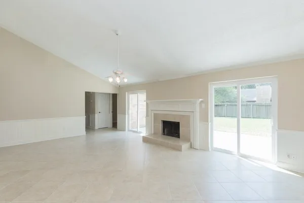 a view of an empty room with a fireplace and a window