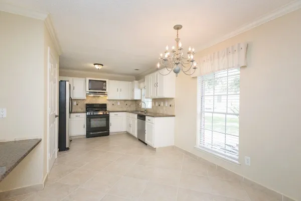 a large kitchen with kitchen island white cabinets and stainless steel appliances