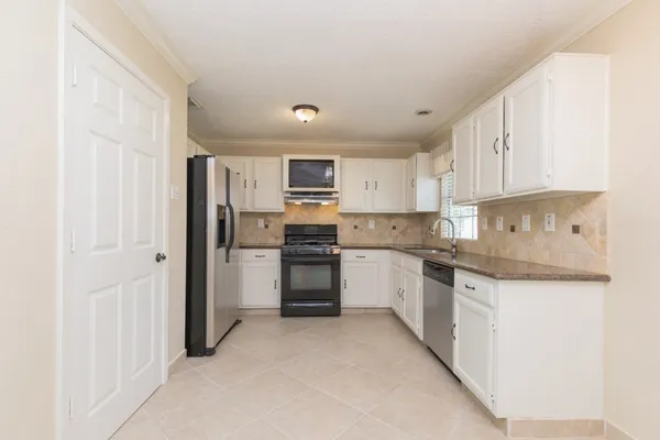 a kitchen with a refrigerator a sink and cabinets