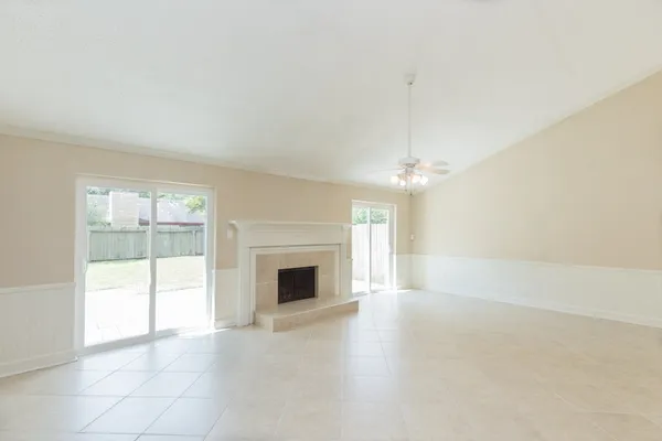 an empty room with fireplace and windows