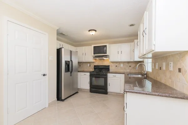 a kitchen with a refrigerator stove top oven and sink