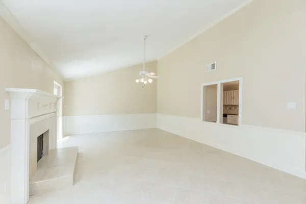 a view of an empty room with a fireplace and a window