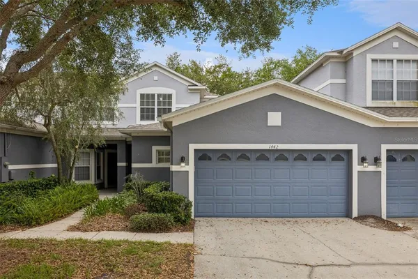 a front view of a house with a yard and garage