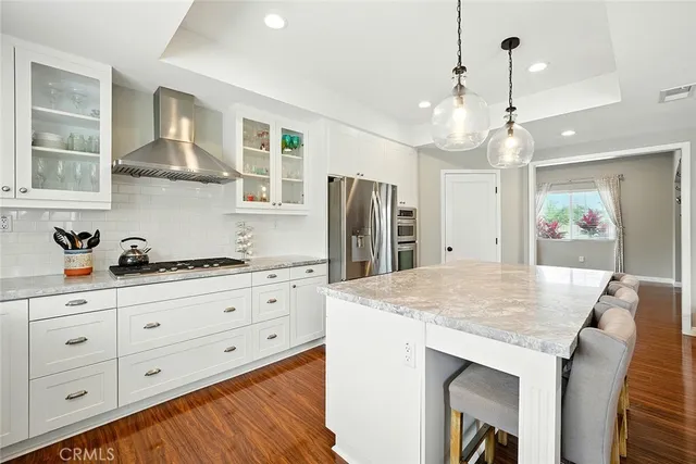 a kitchen with granite countertop cabinets a sink dishwasher and a stove with wooden floor