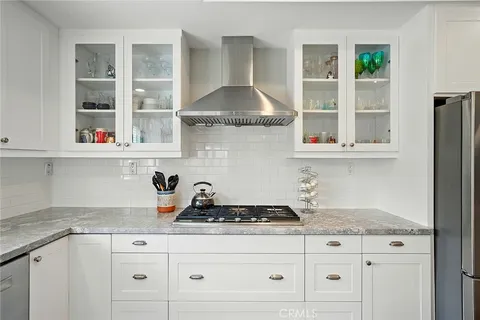 a kitchen with granite countertop white cabinets and window