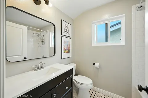 a bathroom with a granite countertop sink mirror and toilet