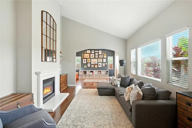 a living room with furniture fireplace and a large window