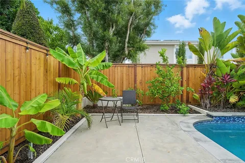 a view of a swimming pool with a yard and plants
