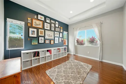 a living room with lots of wooden floor and a book shelf