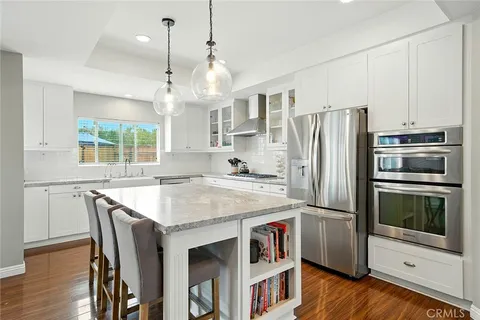 a kitchen with stainless steel appliances a stove a refrigerator and a kitchen island