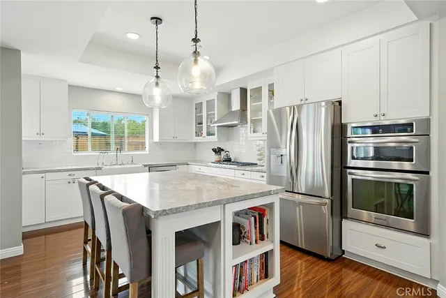 a kitchen with stainless steel appliances a stove a refrigerator and a kitchen island