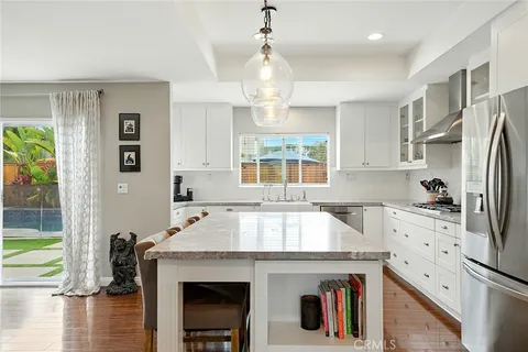a kitchen with stainless steel appliances a stove refrigerator and a sink